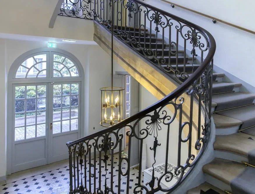 Escalier d'hôtel particulier éclairé par une lanterne ancienne